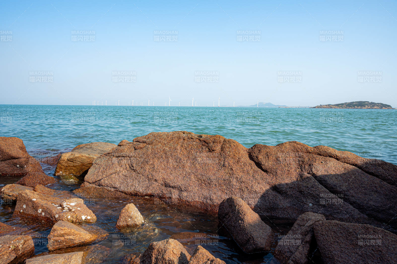 海边岩石与风力发电机图片