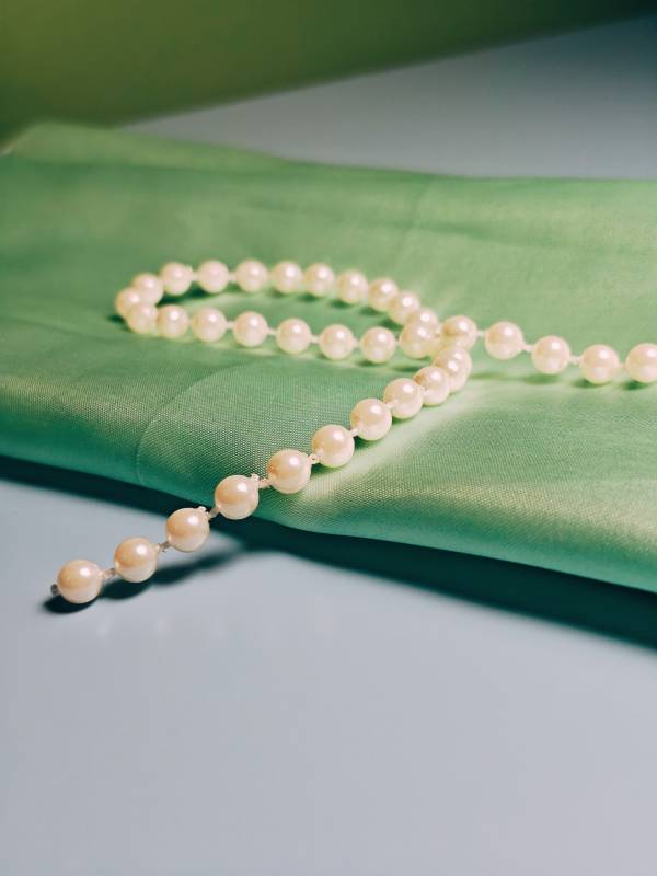 珍珠项链与绿色布料图片
