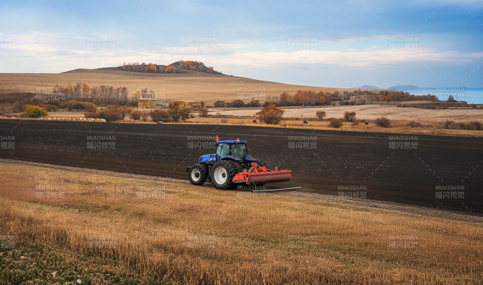 内蒙草原秋日田野上的拖拉机图片
