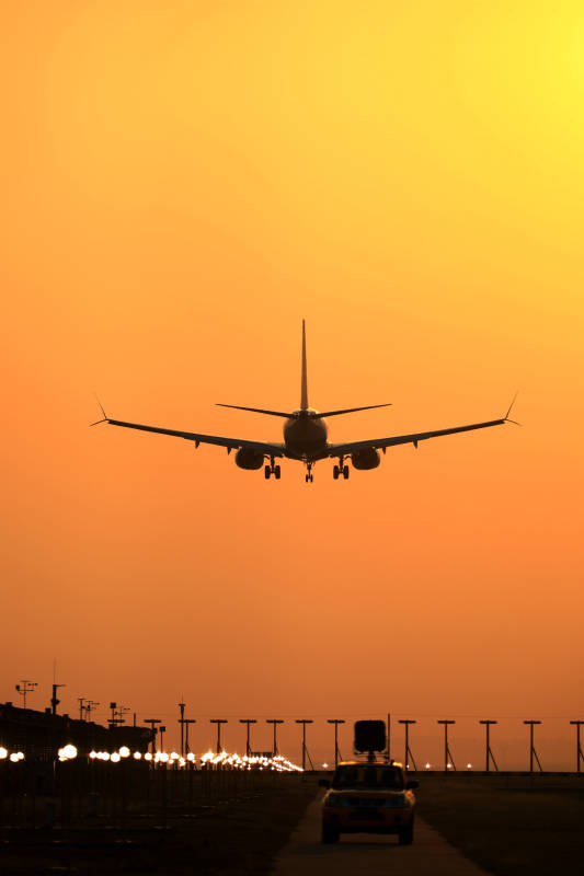 夕阳下的飞机降落图片