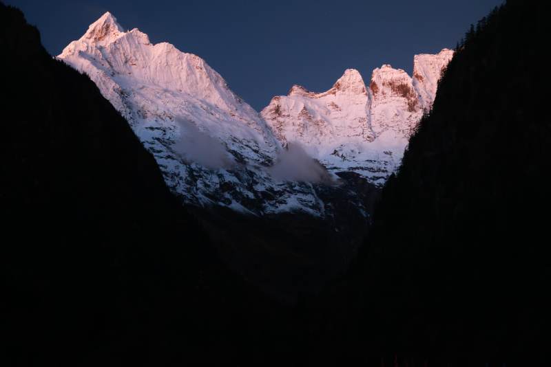 雨崩的雪峰晨曦图片