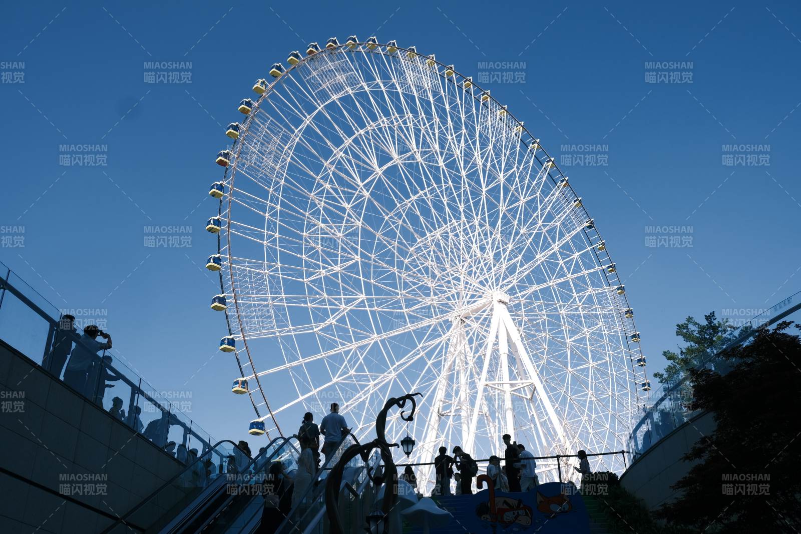 摩天轮下的行人流图片