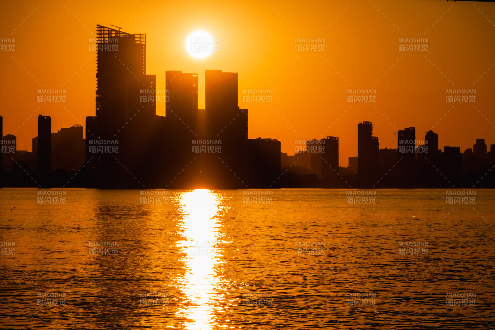 城市剪影夕阳映水图片