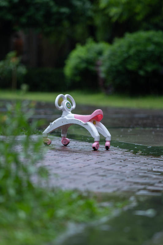 雨中闲置的儿童滑板车图片