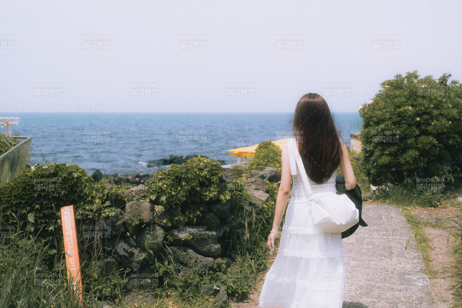 海边漫步的白衣女子图片