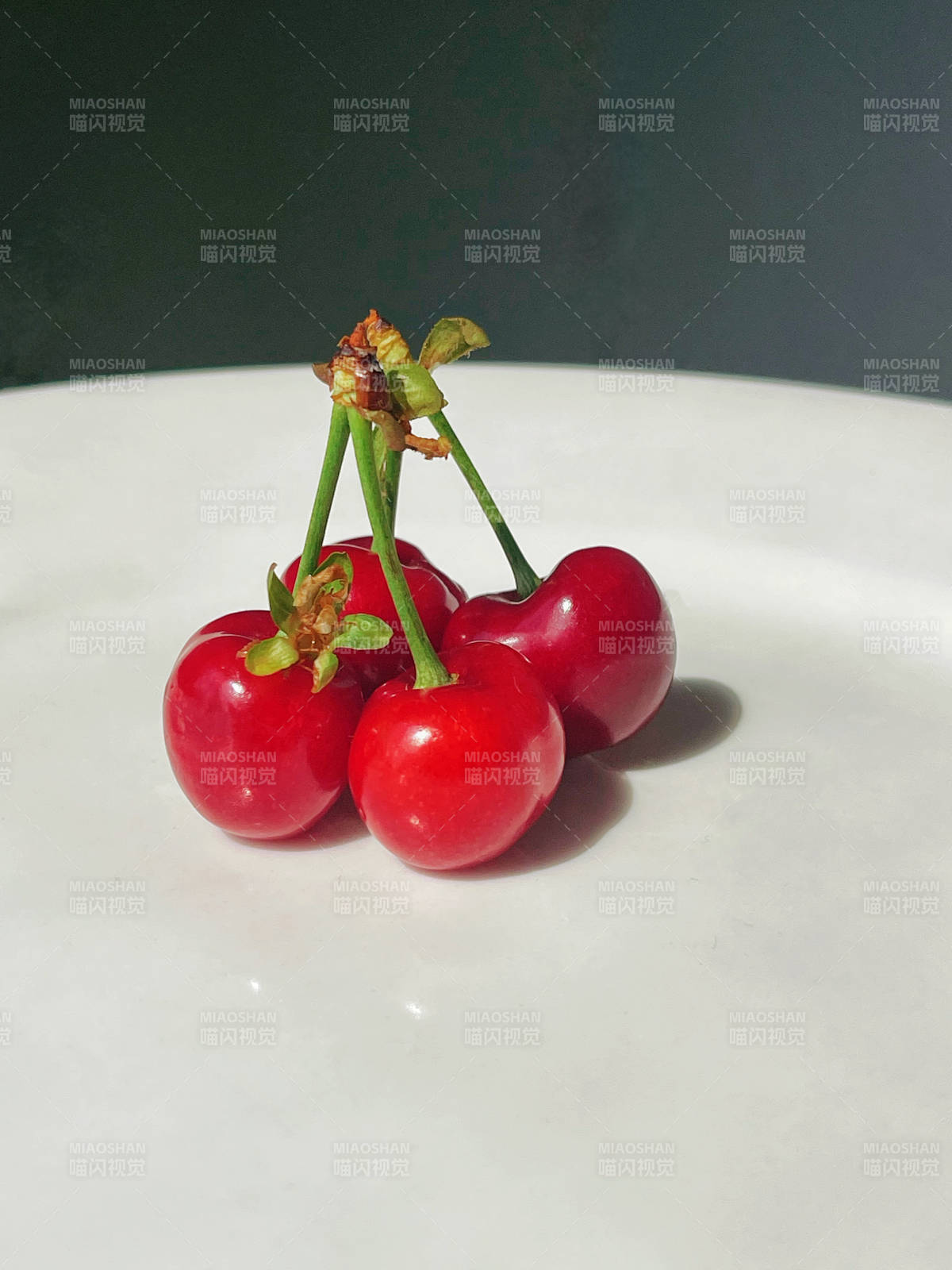 白色盘中四颗红樱桃开花图片