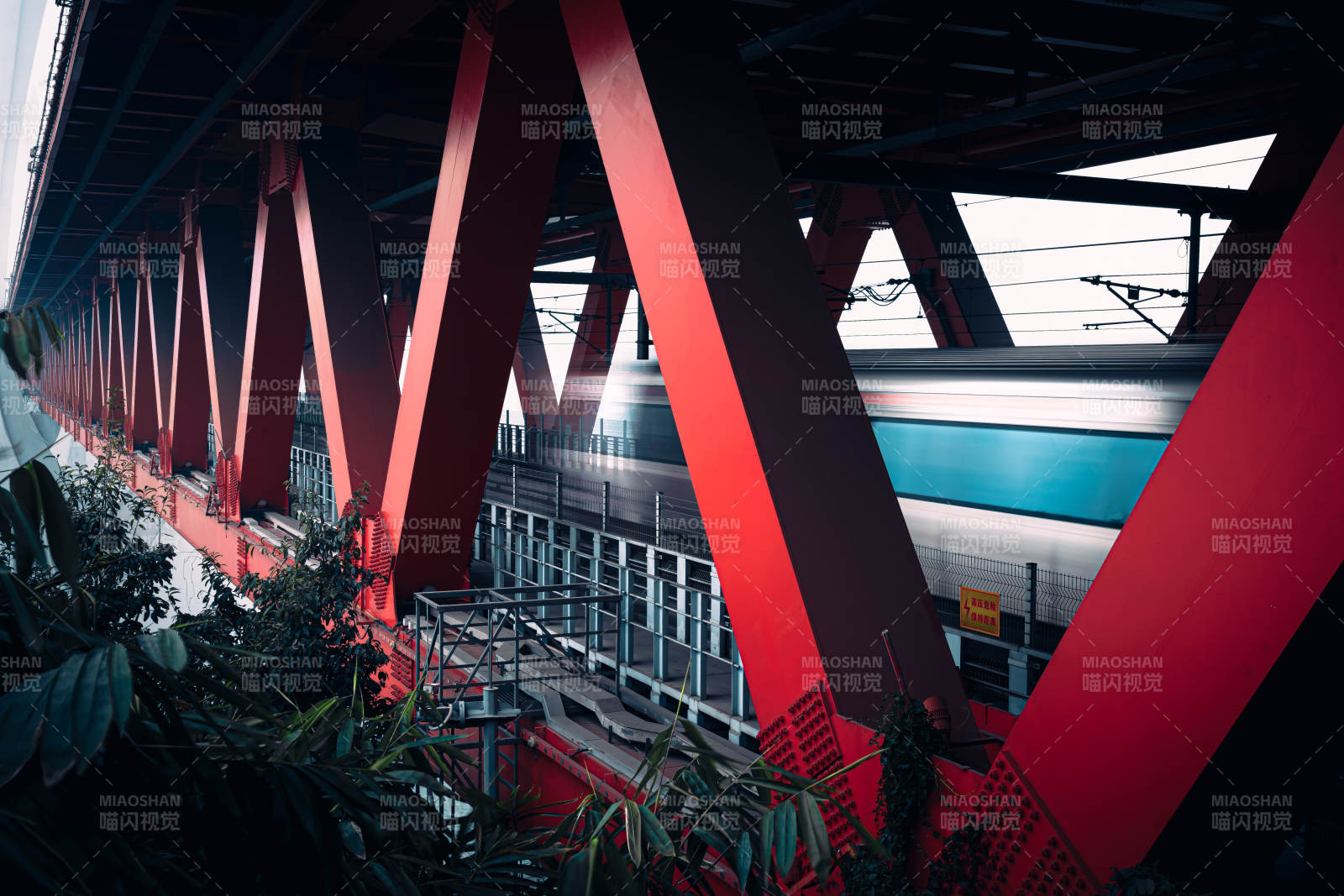 高速列车穿过红色桥梁图片