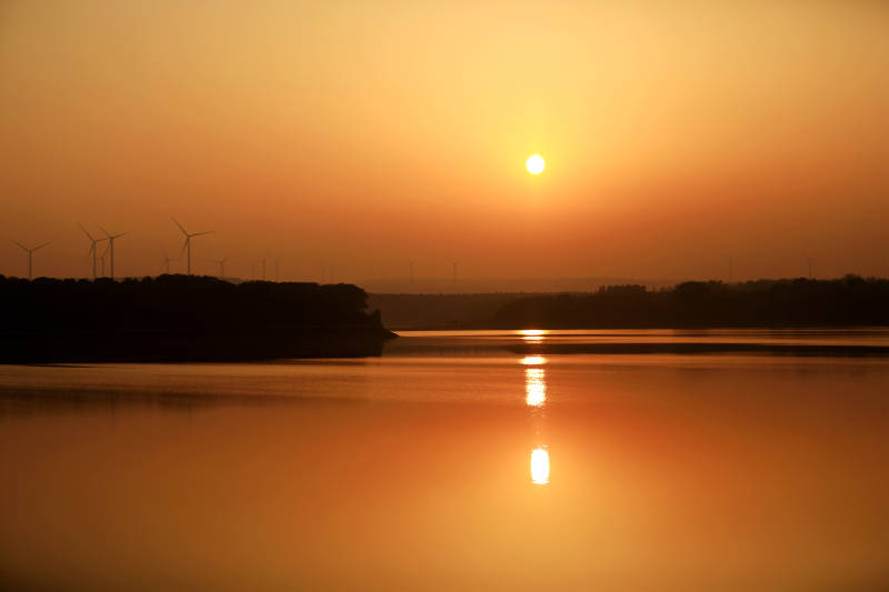 夕阳映湖风车影图片