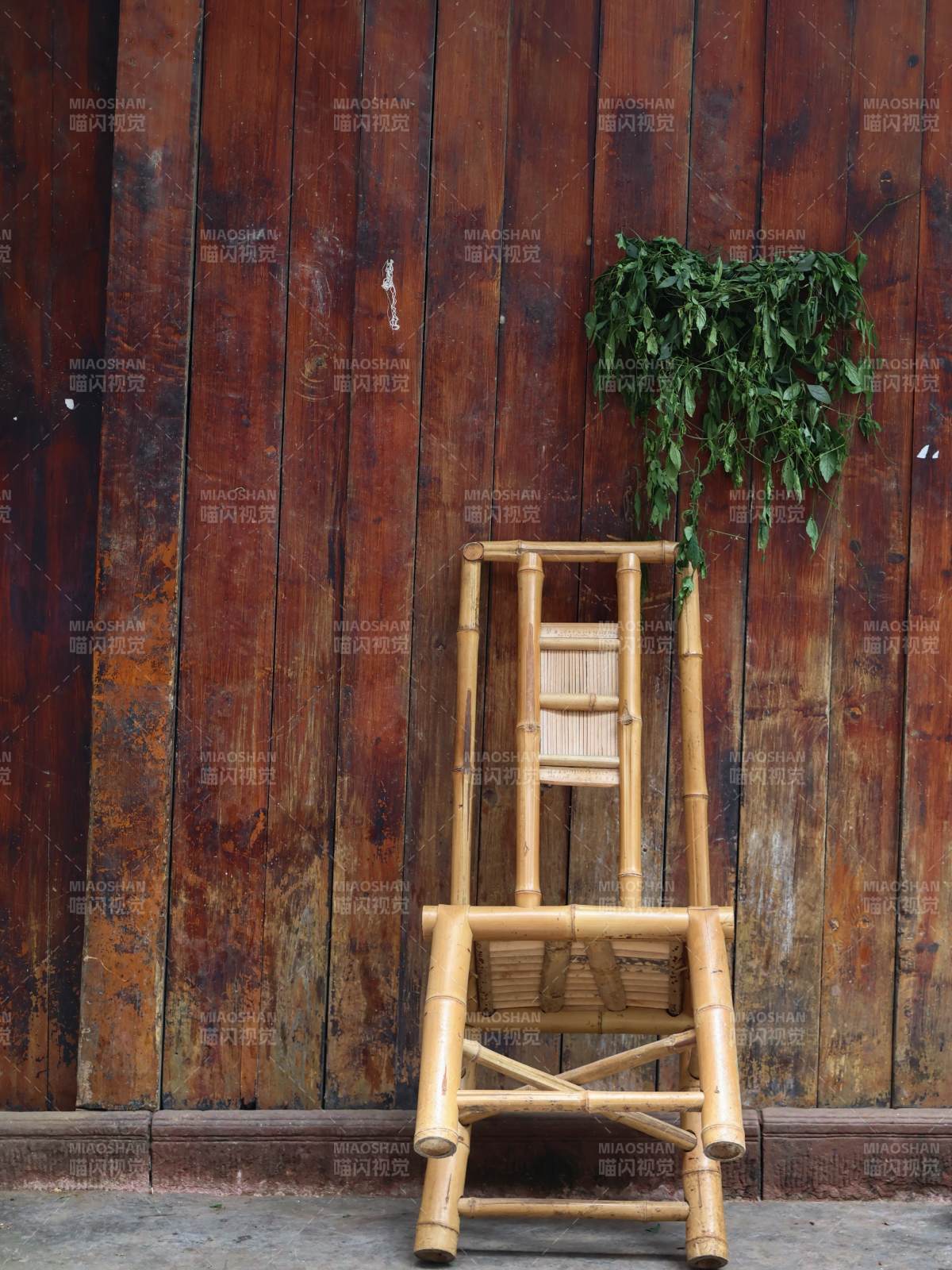 竹椅绿植靠旧墙图片