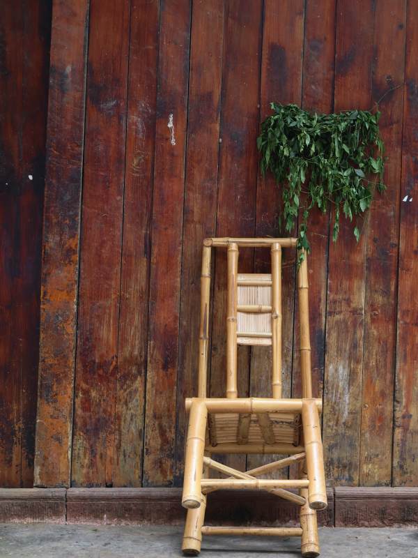 竹椅绿植靠旧墙图片