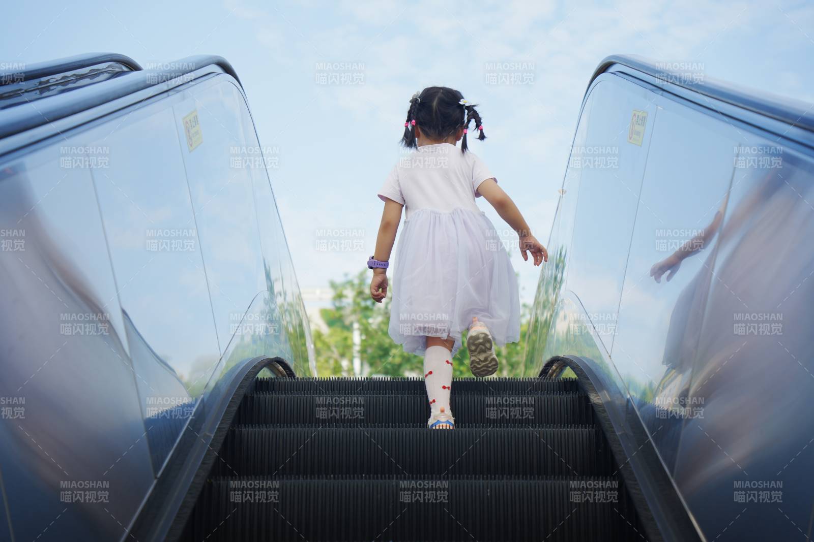 小女孩登上自动扶梯图片