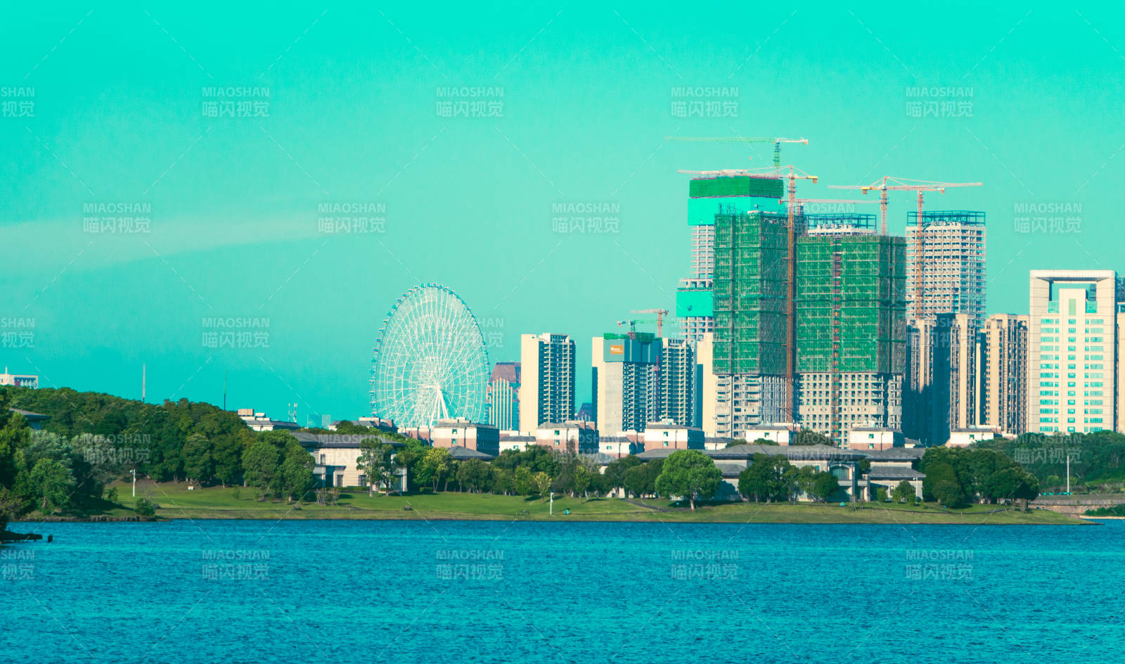 湖畔摩天轮与城市天际线图片