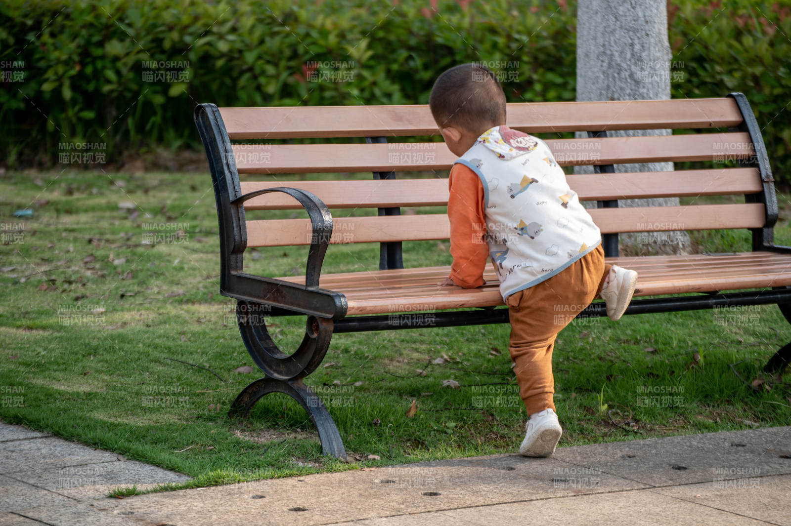 小孩爬公园长椅图片