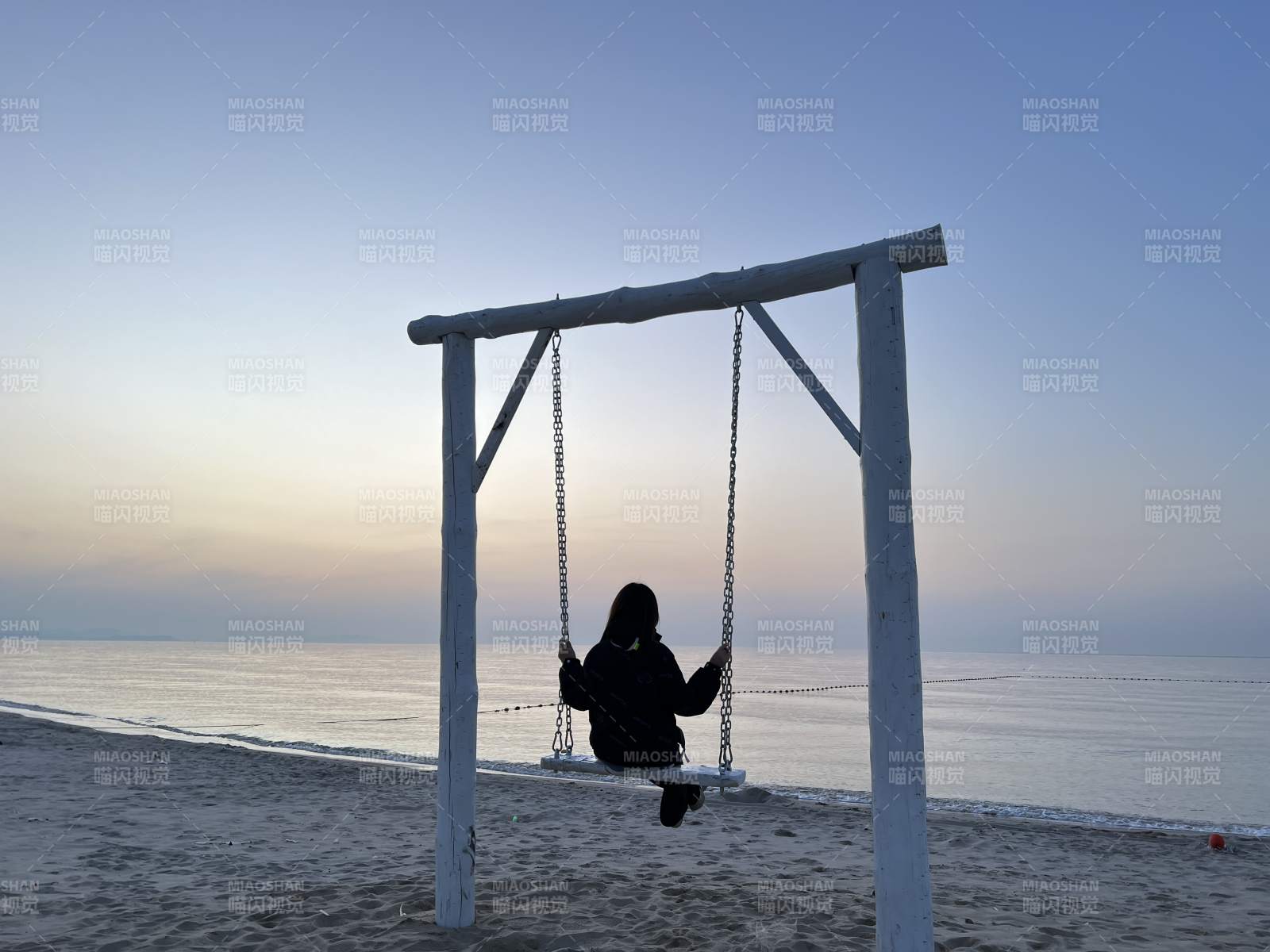 海边日落 一人独荡秋千图片