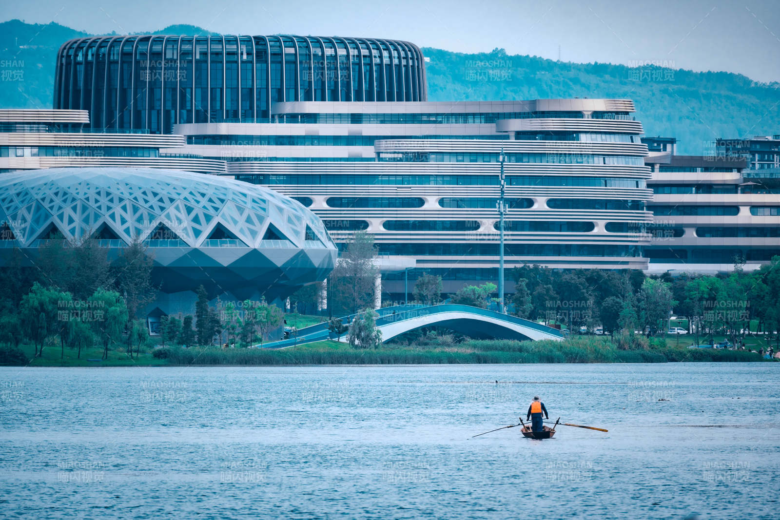 兴隆湖畔现代建筑与划船人影图片