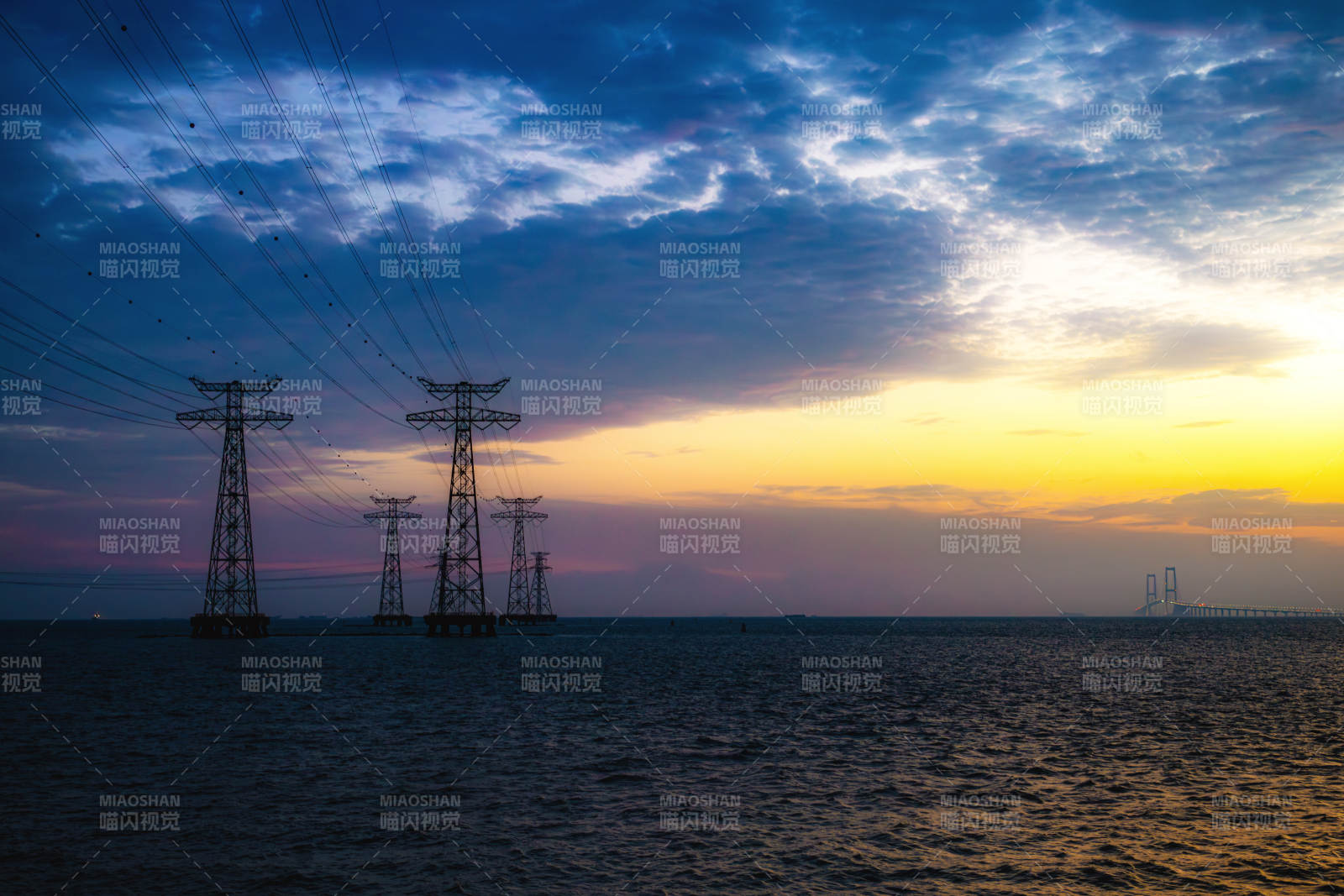 海上日落与电力塔影图片