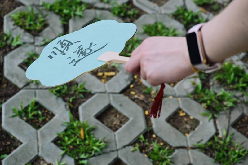 手握蓝色扇子 草地上漫步图片