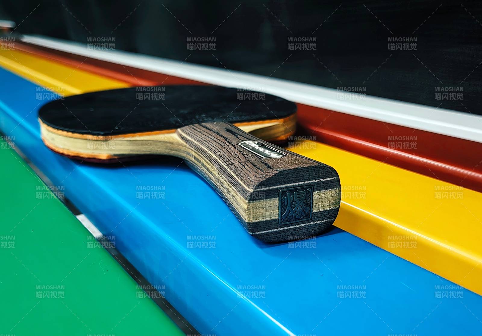 乒乓球拍静置于彩色桌边图片