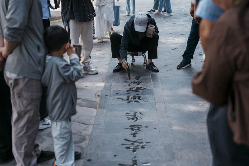 街头书法表演吸引众人观看图片