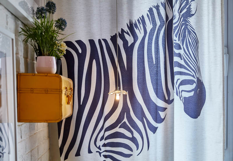 斑马图案窗帘与黄色装饰柜图片