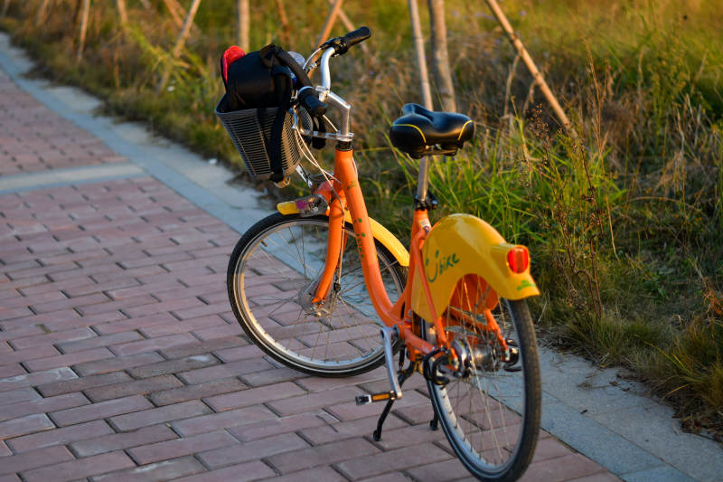 橙色共享单车停在路边图片