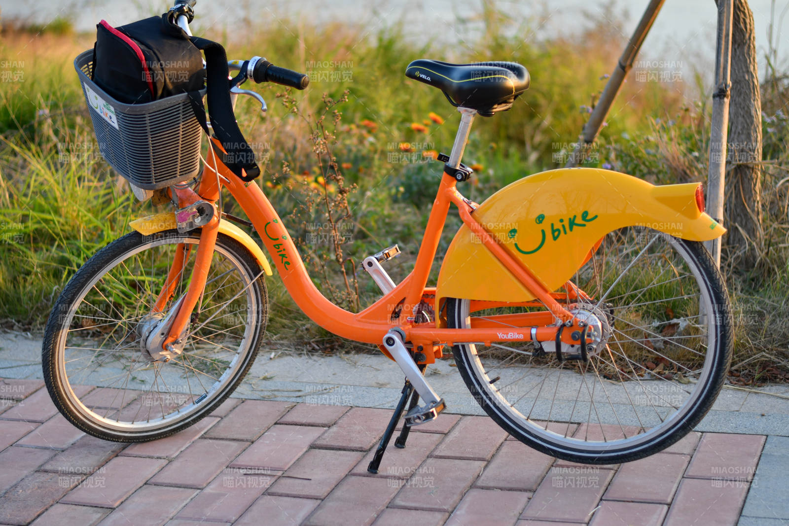 橙色共享单车停在路边图片