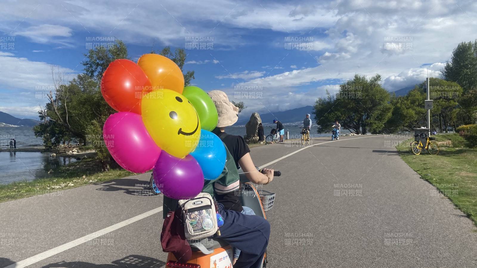 彩色气球点缀湖畔骑行图片