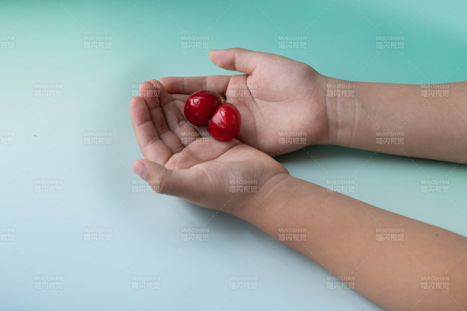 手中捧着两颗红樱桃图片