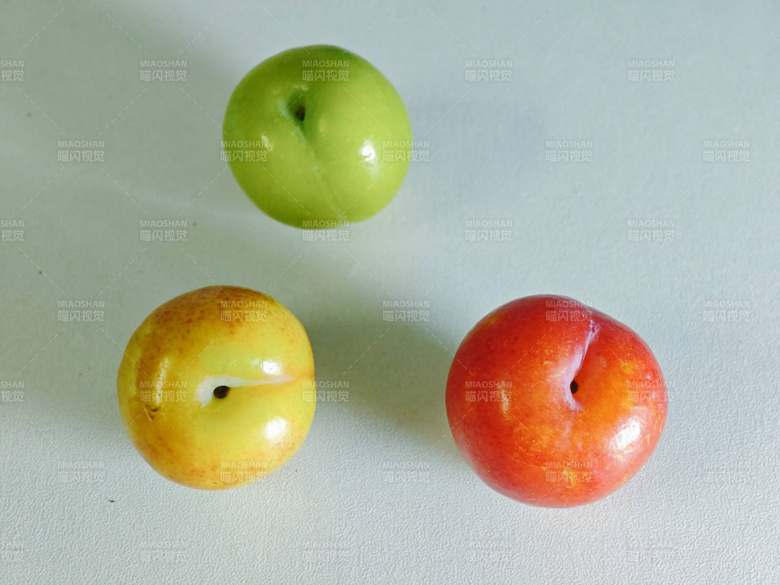 三颗色彩各异的果实图片