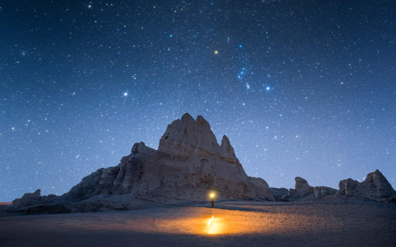 星空下的孤灯与山影图片