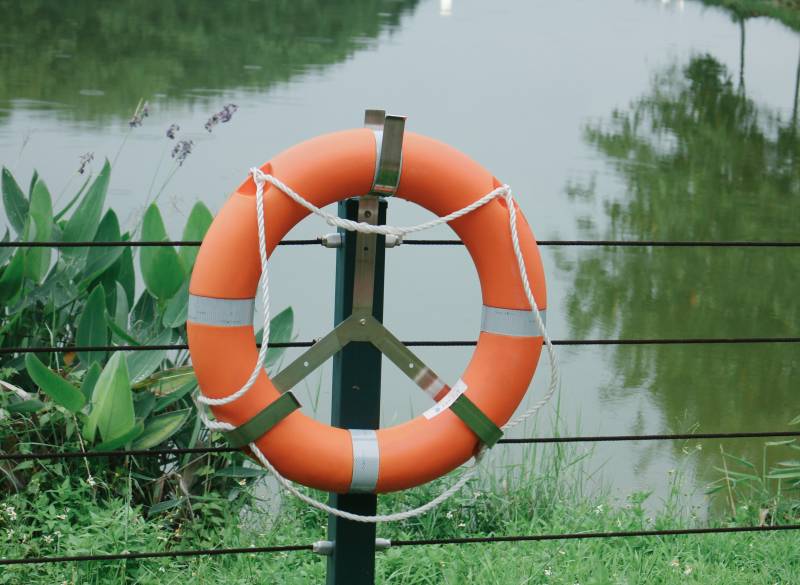 橙色救生圈挂在栏杆上图片