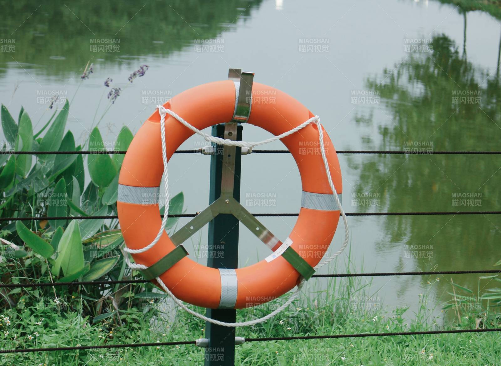 橙色救生圈挂在栏杆上图片