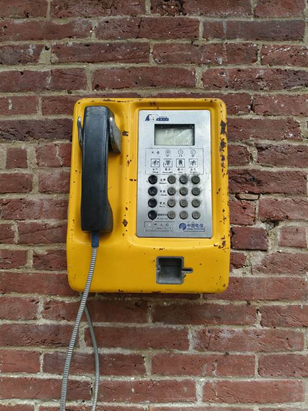 老旧黄色公共电话机图片