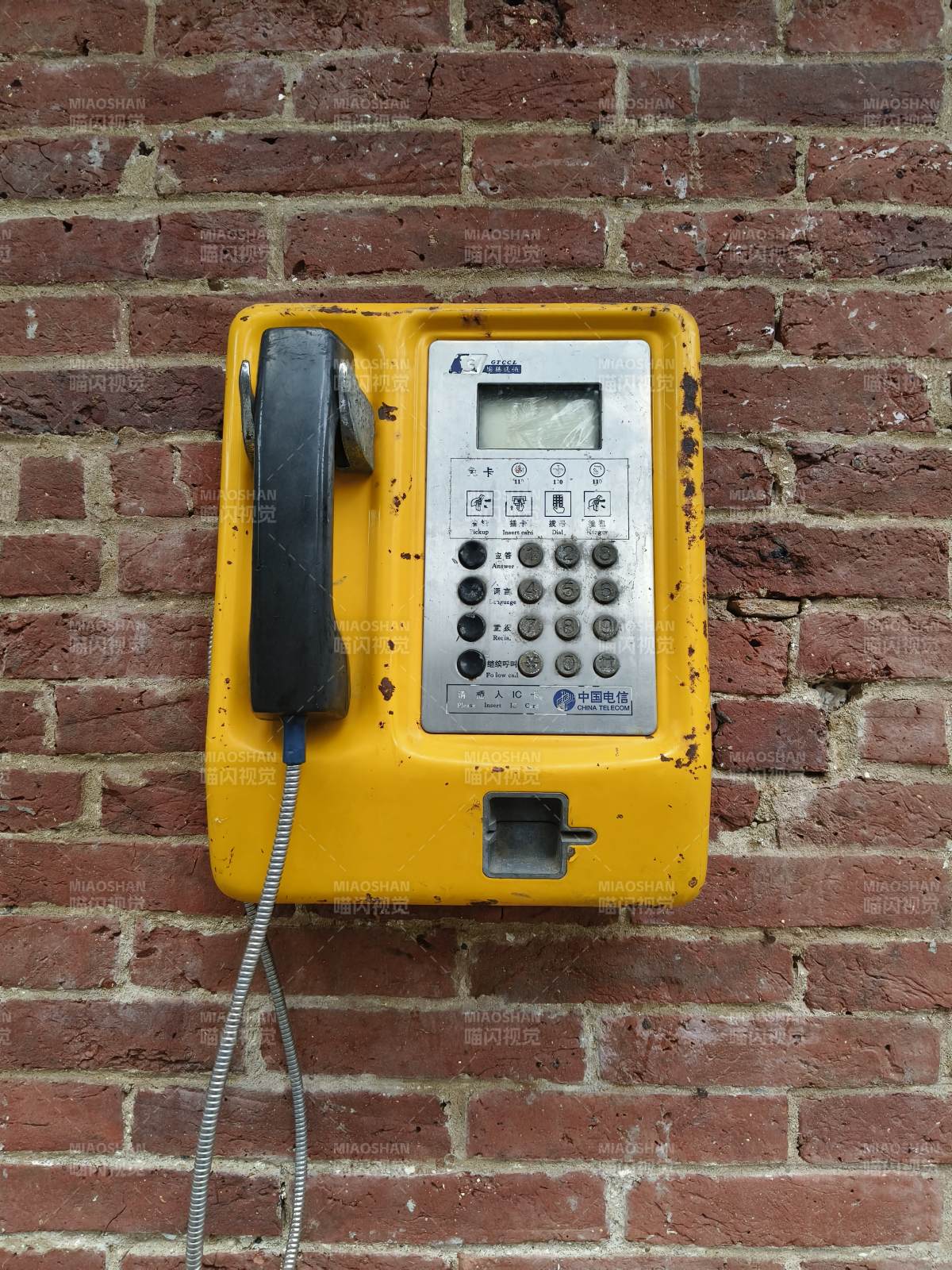 老旧黄色公共电话机图片
