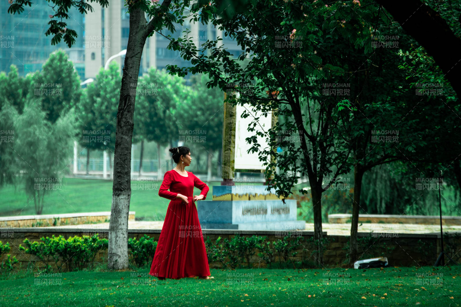 红裙舞者绿荫间图片