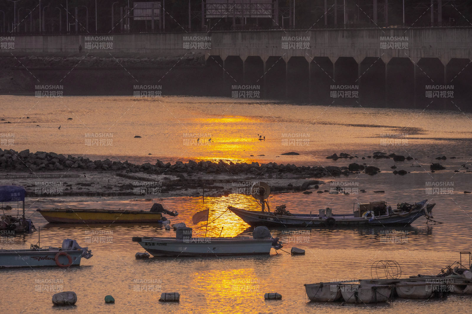 夕阳下的波光粼粼海面和渔船图片
