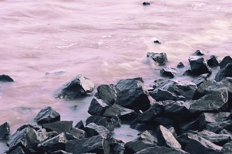 海边岩石与粉色海水图片