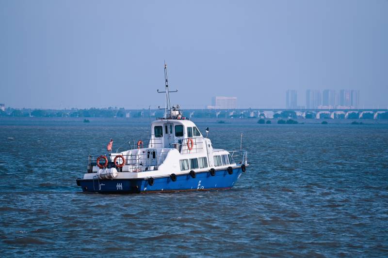 江上航行的蓝色船只图片