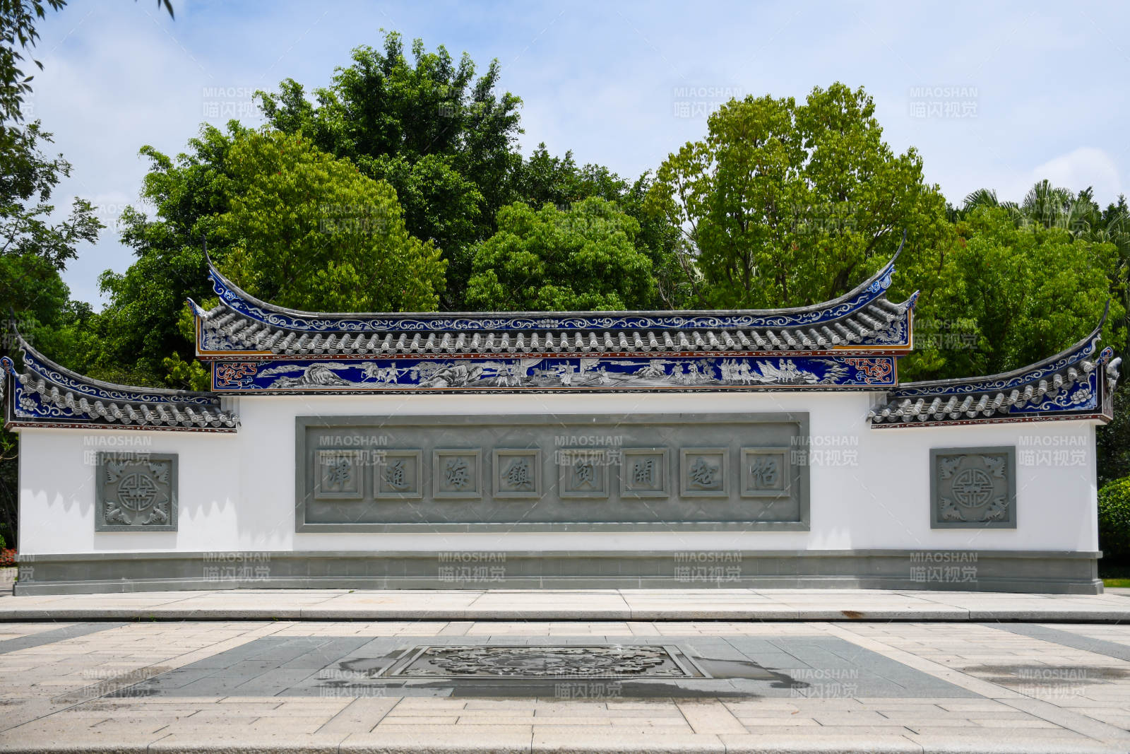 传统建筑墙景与绿树相映图片