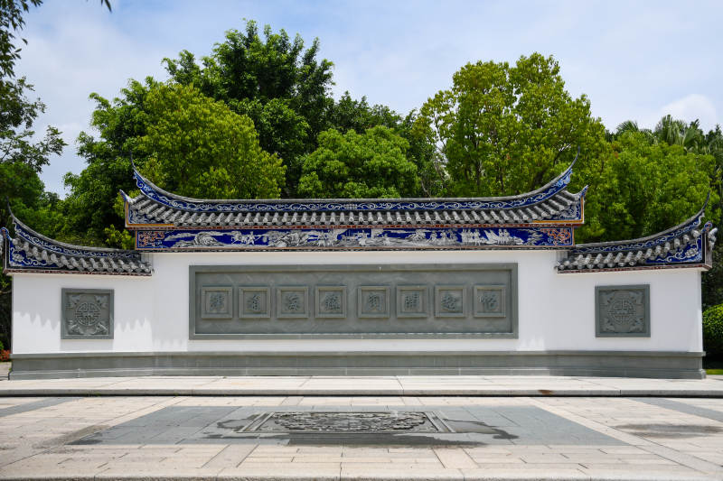 传统建筑墙景与绿树相映图片