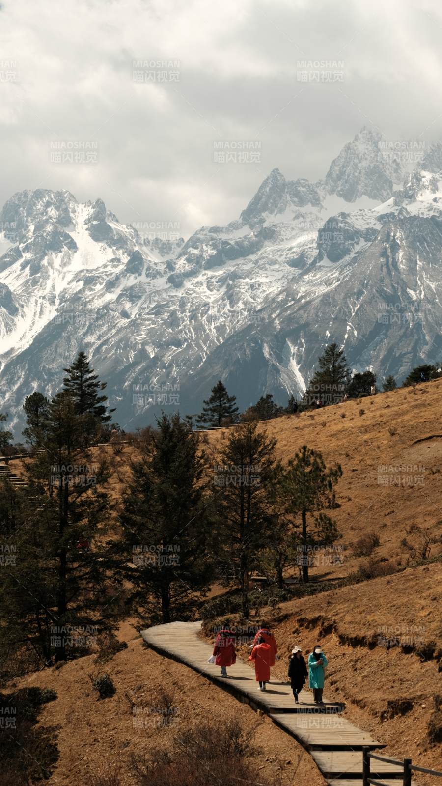雪山脚下漫步的行人图片