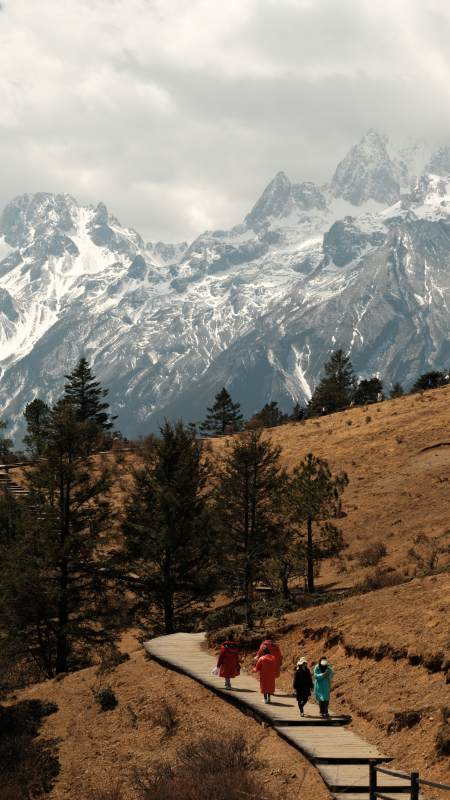 雪山脚下漫步的行人图片