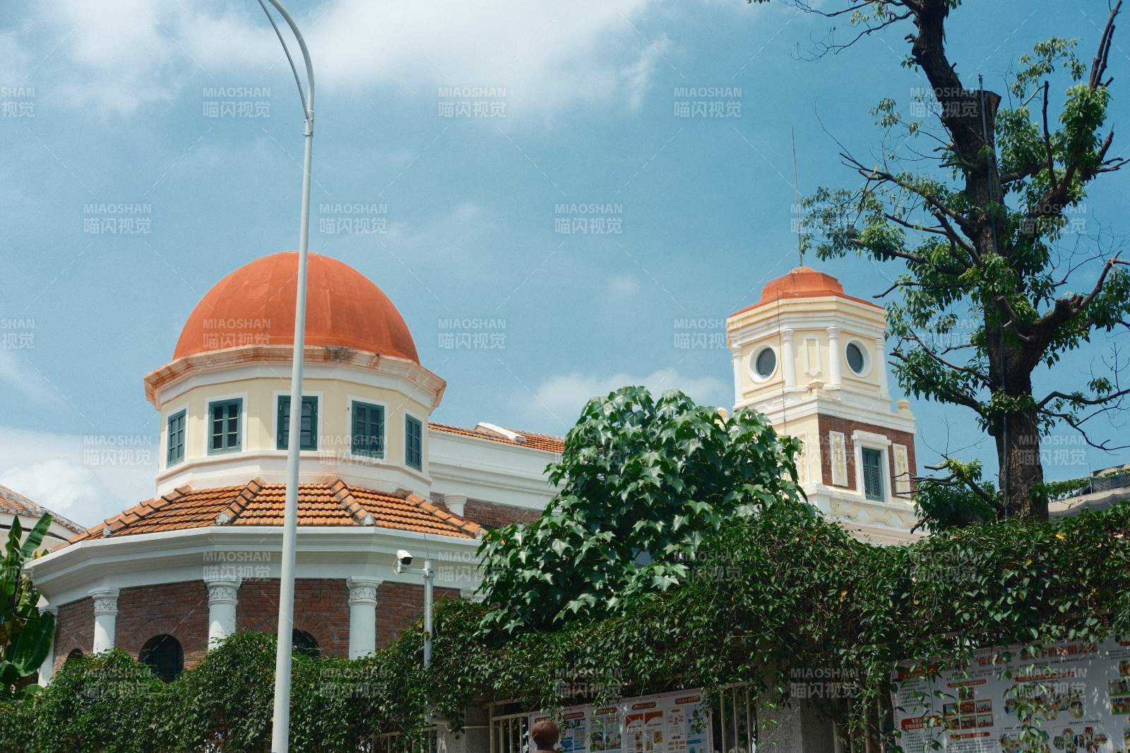 橙顶白墙建筑与绿植相映图片