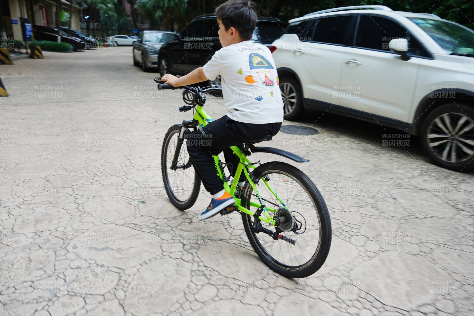 小男孩骑着绿色自行车图片
