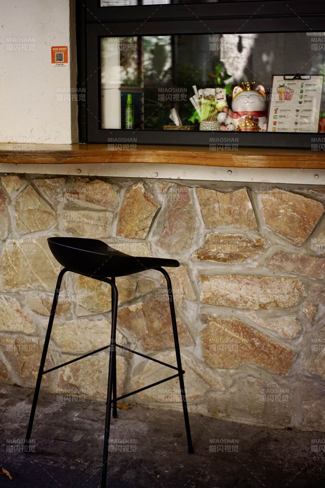 石墙旁的黑色吧台椅图片