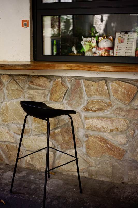 石墙旁的黑色吧台椅图片