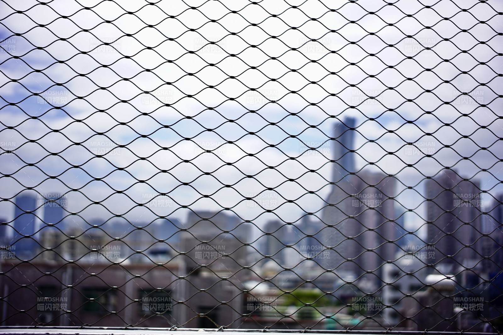 城市远景透过网状围栏图片