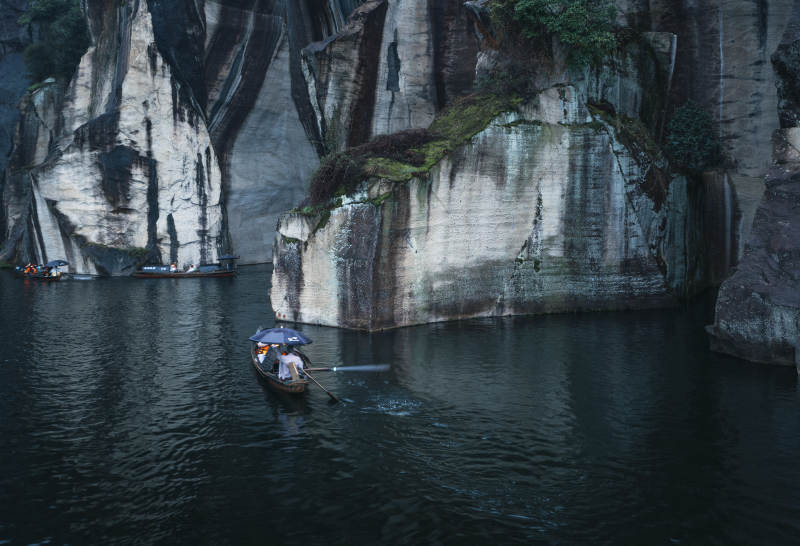 雨中泛舟 山崖静谧图片
