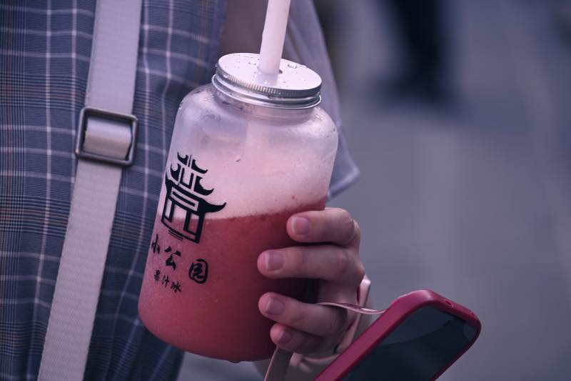 手握奶茶 手机相伴图片