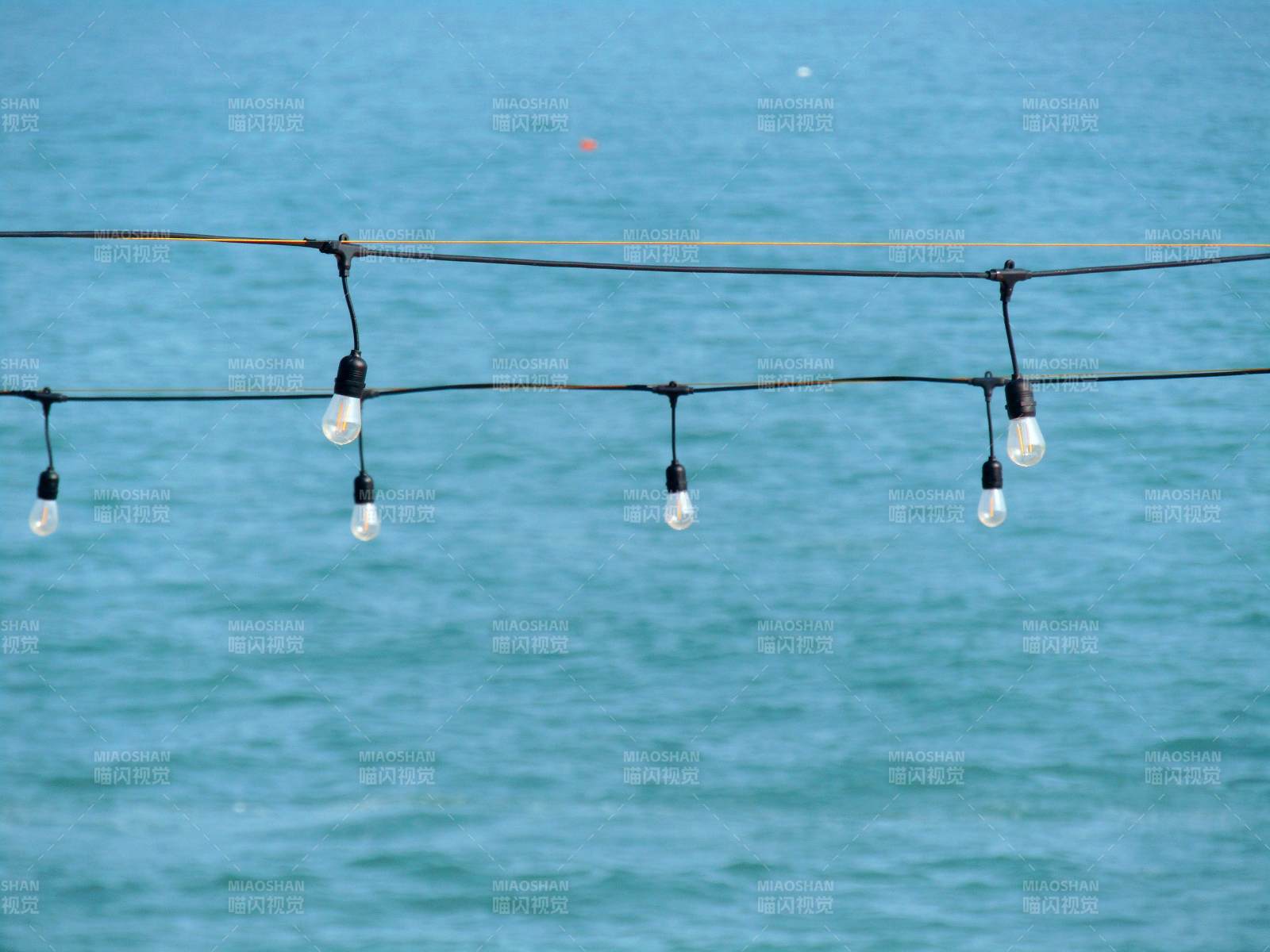 海边的灯串与碧海蓝天图片